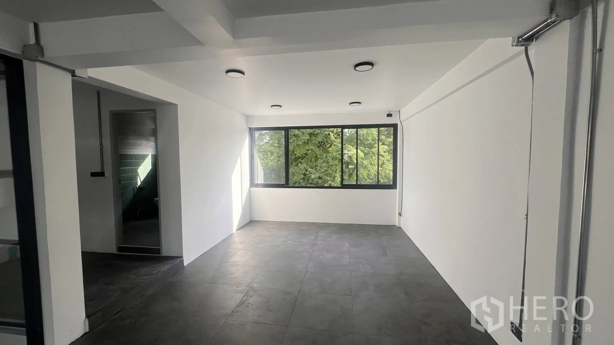 โฮมออฟฟิศ for rent or sale in Phra Khanong, Bangkok - ห้องสว่างมีหน้าต่างบานกว้างหันสู่ต้นไม้และทางเข้าห้องน้ำ.