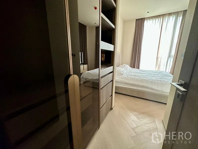 公寓 出租 - 步入式衣帽间过道，镜面衣柜与开放层架，通向采光良好的卧室。