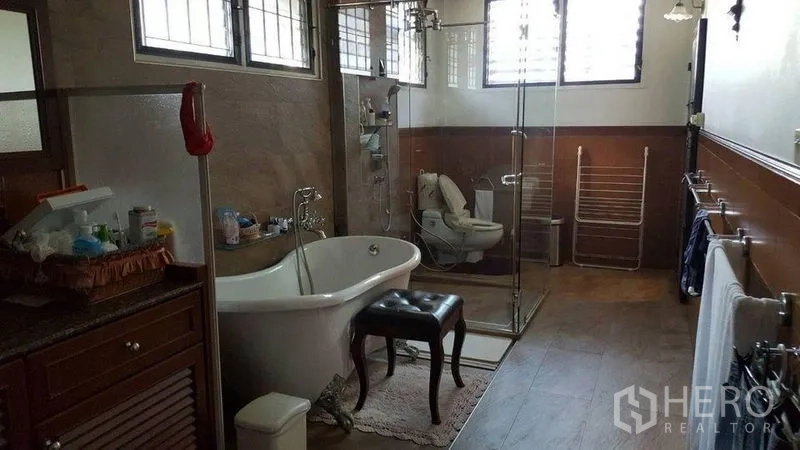 Detached House for rent in Bang Kapi, Bangkok - Bathroom with freestanding bathtub, glass shower and high windows.