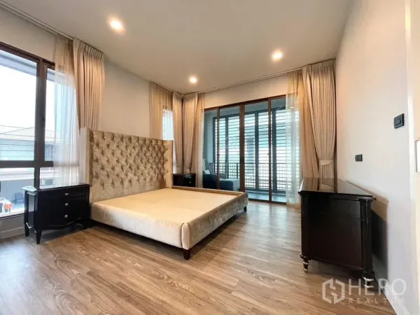 Detached House for rent in Bang Kapi, Bangkok - Spacious master bedroom with access to a balcony and floor-to-ceiling windows.