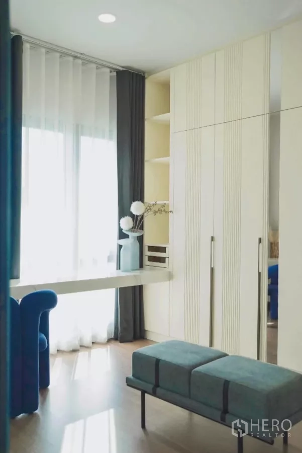 独立式住宅 出租在Bang Phli, Samut Prakan - 卧室一角，衣柜、长凳与自然采光。