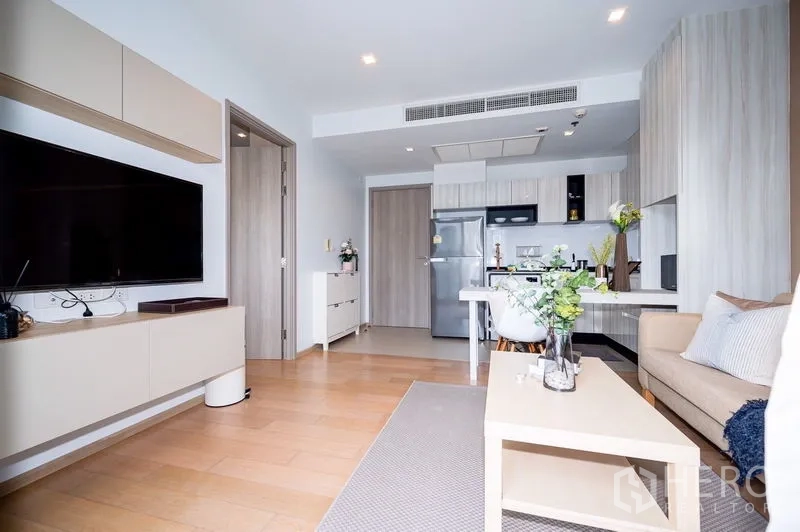 Condominium for rent or sale in Watthana, Bangkok - Modern open kitchen with built-in cabinets and large fridge connected to the living area and TV unit.