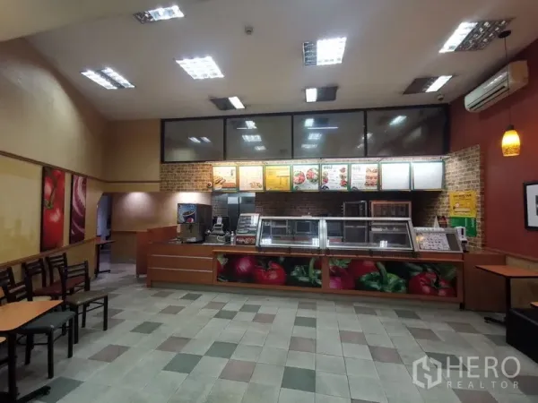 店屋 出租在Bangkok - 室内餐饮空间，点餐吧台、菜单灯箱与瓷砖地面。