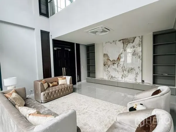 Detached House for rent or sale in Bang Phli, Samut Prakan - Living area with marble feature TV wall, built-in shelving and cassette air conditioning.