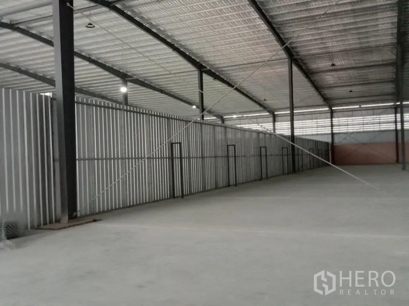 Factory for rent in Ban Phaeo, Samut Sakhon - Clear-span warehouse bay with metal cladding and bright lighting for production or storage.
