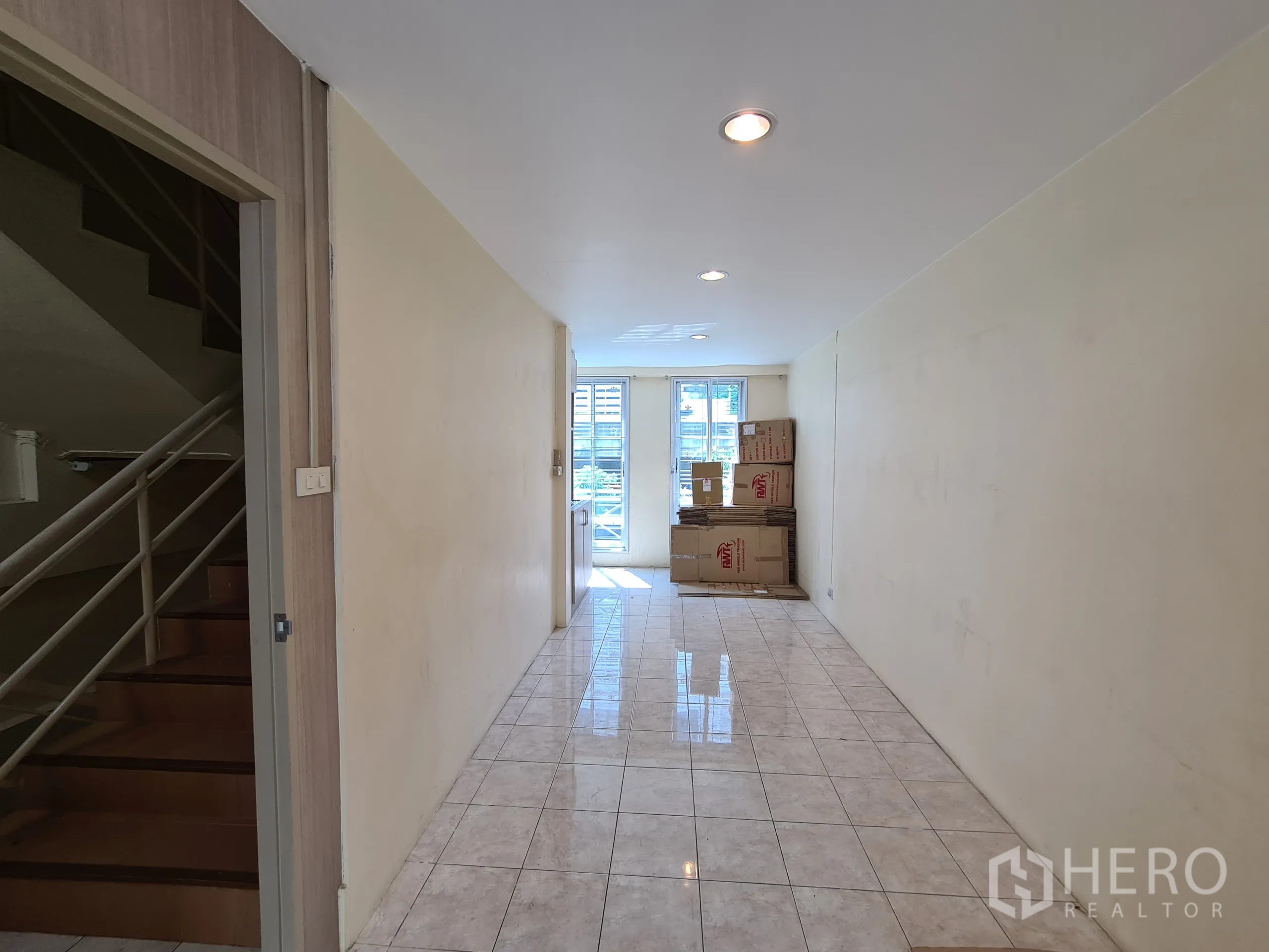 店屋 出租或出售在Sathon, Bangkok - 门厅铺地砖，设有通往上层的楼梯与玻璃后门。