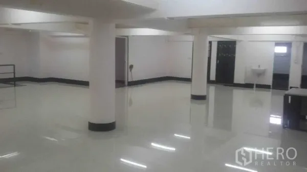 Shophouse for rent in Sathon, Bangkok - Open retail space with pillars, side rooms and a sink area, ideal for showroom or studio use.