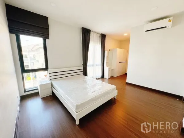 Detached House for rent in Bang Phli, Samut Prakan - Bright bedroom with double bed, wood flooring, floor-to-ceiling windows and air conditioning.