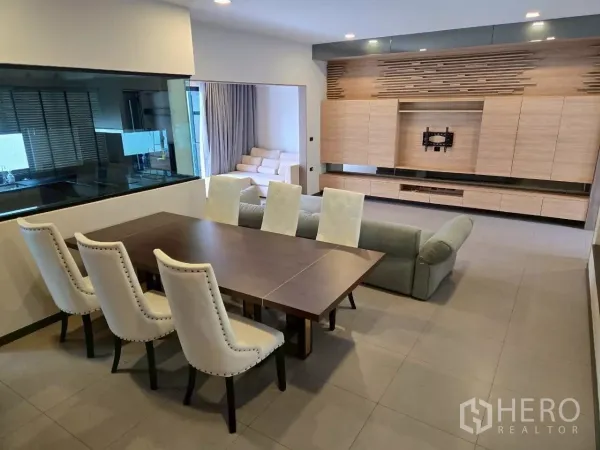 Townhouse for rent in Bang Phli, Samut Prakan - Dining set beside a glass kitchen window and a built-in media wall with light wood cabinetry.
