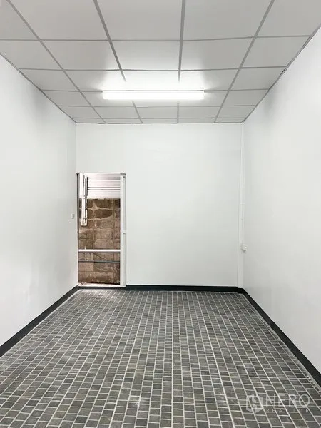 Warehouse for rent in Wang Thonglang, Bangkok - Compact office room with white walls, ceiling light, and gray tiled floor inside the warehouse.