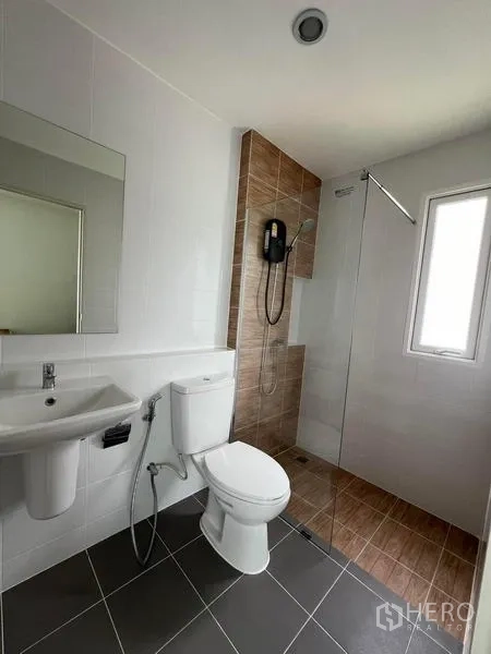 Detached House for rent in Bang Phli, Samut Prakan - Second bathroom featuring a glass shower screen, water heater, and tiled walls.