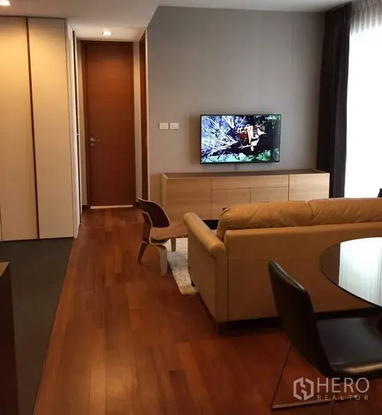 公寓 出租在Khlong Toei, Bangkok - 开放式客餐厅，木地板，沙发、木质电视柜与圆形餐桌。