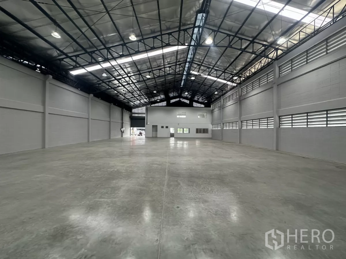 Factory for rent in Bang Phli, Samut Prakan - Expansive warehouse hall with insulated roof and office block at the far end.