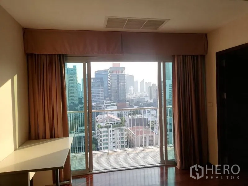 Condominium for rent in Watthana, Bangkok - Sliding glass doors open to a balcony with wide city skyline views.
