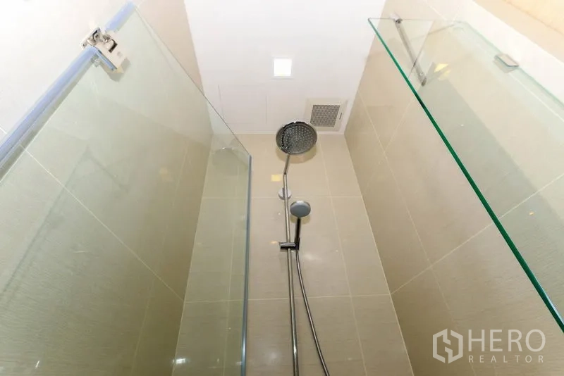 คอนโด ให้เช่าในKhlong Toei, Bangkok - ห้องน้ำกั้นกระจกพร้อมเรนชาวเวอร์และฝักบัวมือถือ ปูกระเบื้องโทนสว่าง