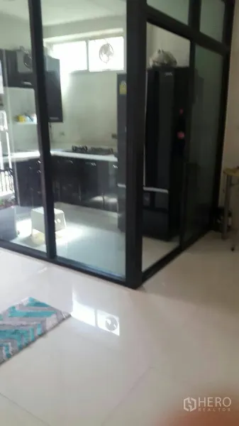 ทาวน์เฮาส์ ให้เช่าในSuan Luang, Bangkok - ครัวปิดกระจกพร้อมตู้สีดำ เตาแก๊ส และตู้เย็นขนาดใหญ่ ในโครงการ Noble Cube สวนหลวง