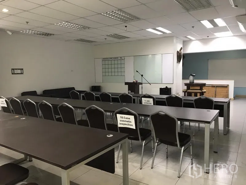 Office Space for rent in Khlong Toei, Bangkok - Large training room with rows of tables and chairs, a podium and multiple whiteboards.
