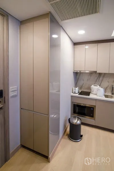 คอนโด ให้เช่าในKhlong Toei, Bangkok - ตู้เก็บของบิวท์อินสูงข้างครัวกะทัดรัดพร้อมไมโครเวฟและเตา