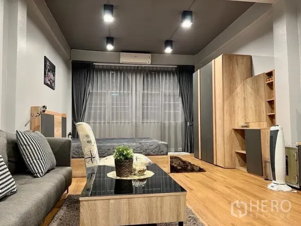 Shophouse for sale in Bang Kho Laem, Bangkok - Open-plan lounge and sleeping area with bed, sofa, wardrobe and soft lighting.