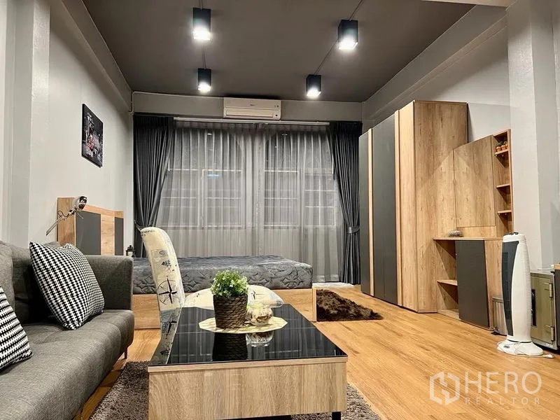 Shophouse for sale in Bang Kho Laem, Bangkok - Open-plan lounge and sleeping area with bed, sofa, wardrobe and soft lighting.