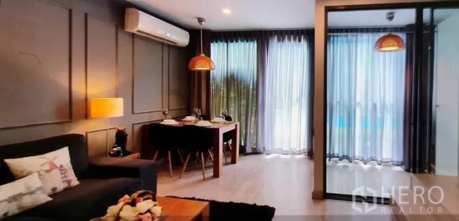 Condominium for rent in Phra Khanong, Bangkok - Bright living and dining area with floor‑to‑ceiling windows and pool view.