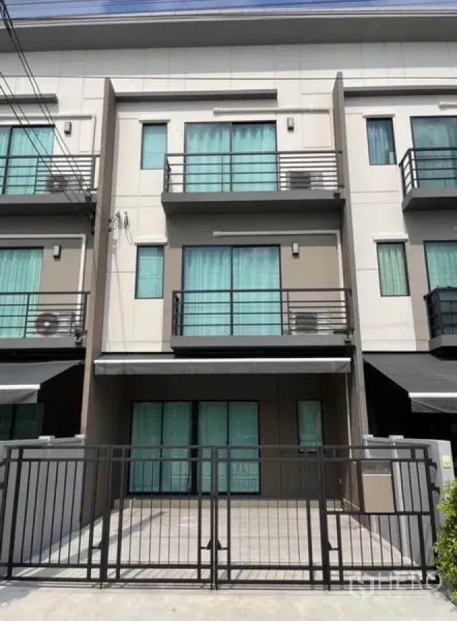 Townhouse for rent in Phasi Charoen, Bangkok - Three-storey modern townhouse exterior with gated parking and balconies.