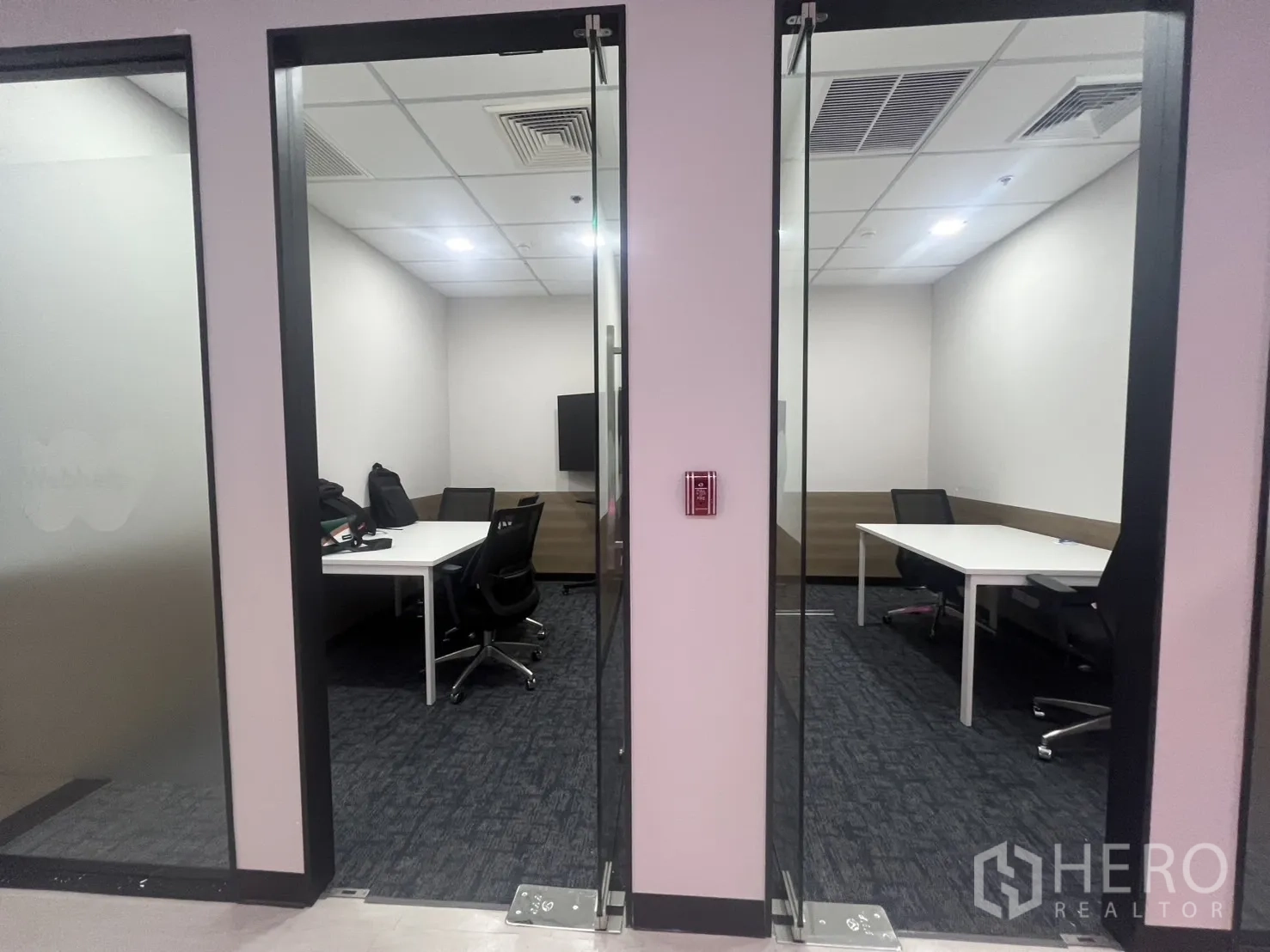 Office Space for rent in Huai Khwang, Bangkok - Two manager rooms with glass doors, white desks, office chairs and a TV monitor.
