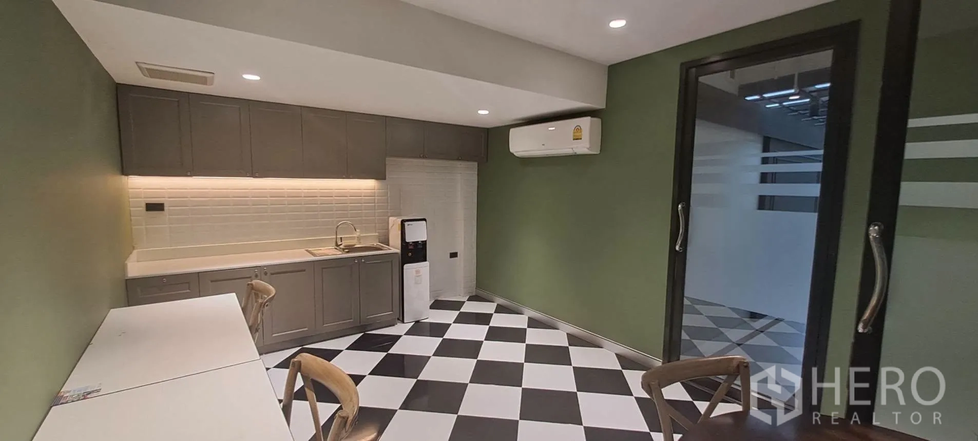 家庭办公室 for rent in Lat Phrao, Bangkok - 茶水间配整排柜体、水槽、空调与黑白棋盘地砖。