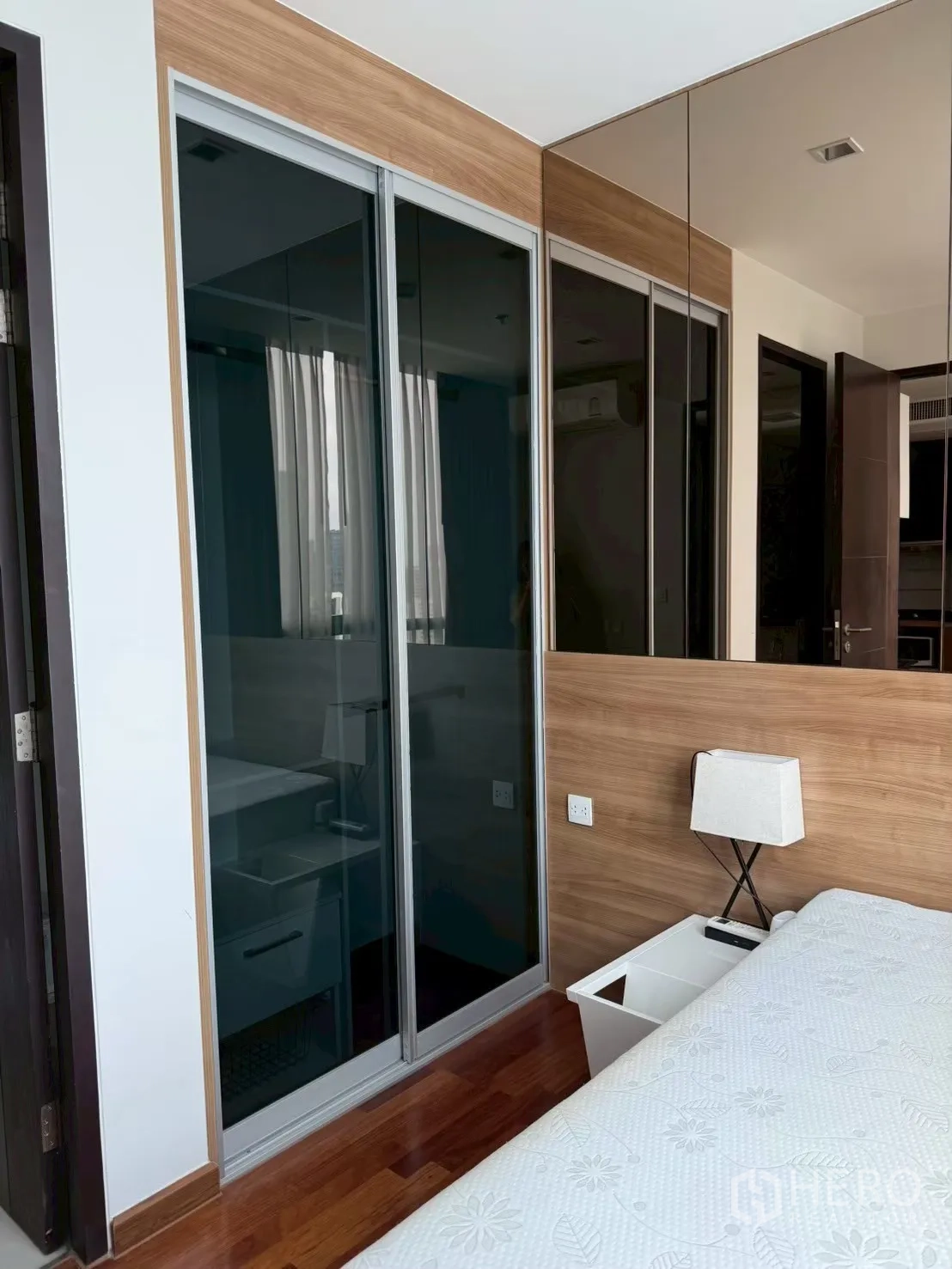 คอนโด for rent in Ratchathewi, Bangkok - มุมห้องนอนพร้อมตู้เสื้อผ้าบานเลื่อนกระจก โต๊ะข้างเตียง และผนังกระจกเงา