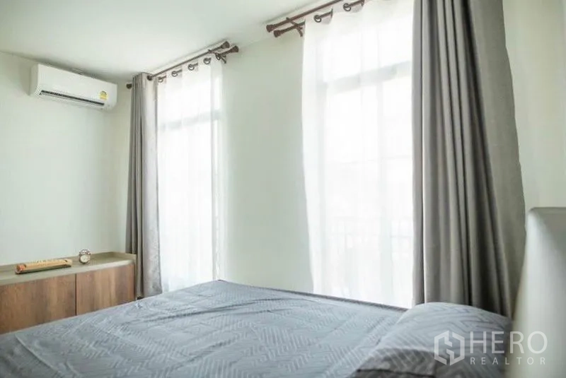 Townhouse for rent in Bang Phli, Samut Prakan - Airy bedroom with sheer curtains, air conditioner and abundant natural light.