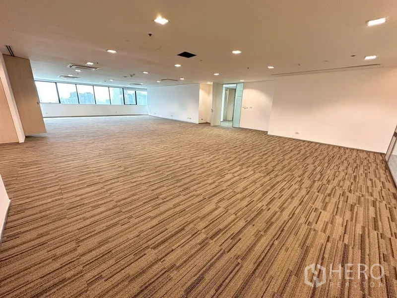 สำนักงาน ให้เช่าในWatthana, Bangkok - โซนสำนักงานแบบเปิด ผนังโค้งติดหน้าต่างยาว ไฟแขวน และพรมโทนกลาง