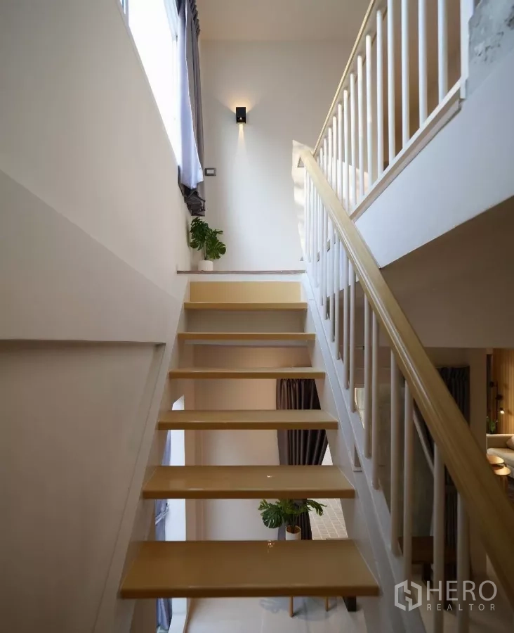 联排别墅 出租或出售在Watthana, Bangkok - 开放式木踏步楼梯与白色栏杆，侧窗采光充足。