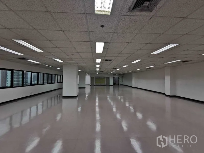 办公空间 出租在Watthana, Bangkok - 从中央视角看空旷办公区，吊顶灯带与整面窗墙。