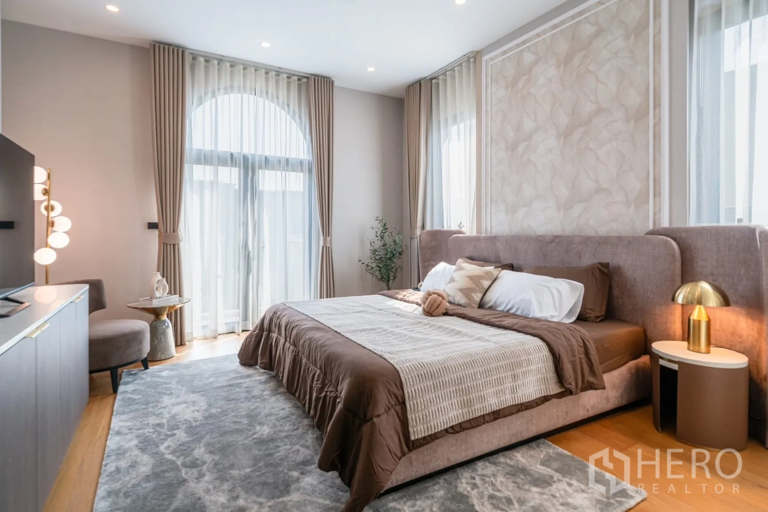 บ้านเดี่ยว for rent or sale in Saphan Sung, Bangkok - ห้องนอนมาสเตอร์มีหน้าต่างโค้ง ผ้าม่านโปร่ง และพรมผืนใหญ่