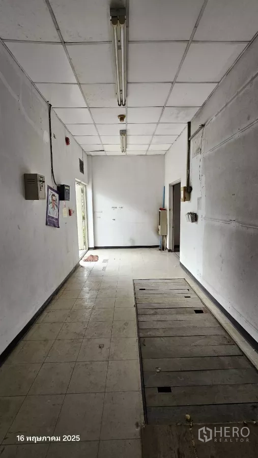 Retail Space for rent in Phra Khanong, Bangkok - Long interior room with tiled floor, drop ceiling and fluorescent lights, showing a side door.
