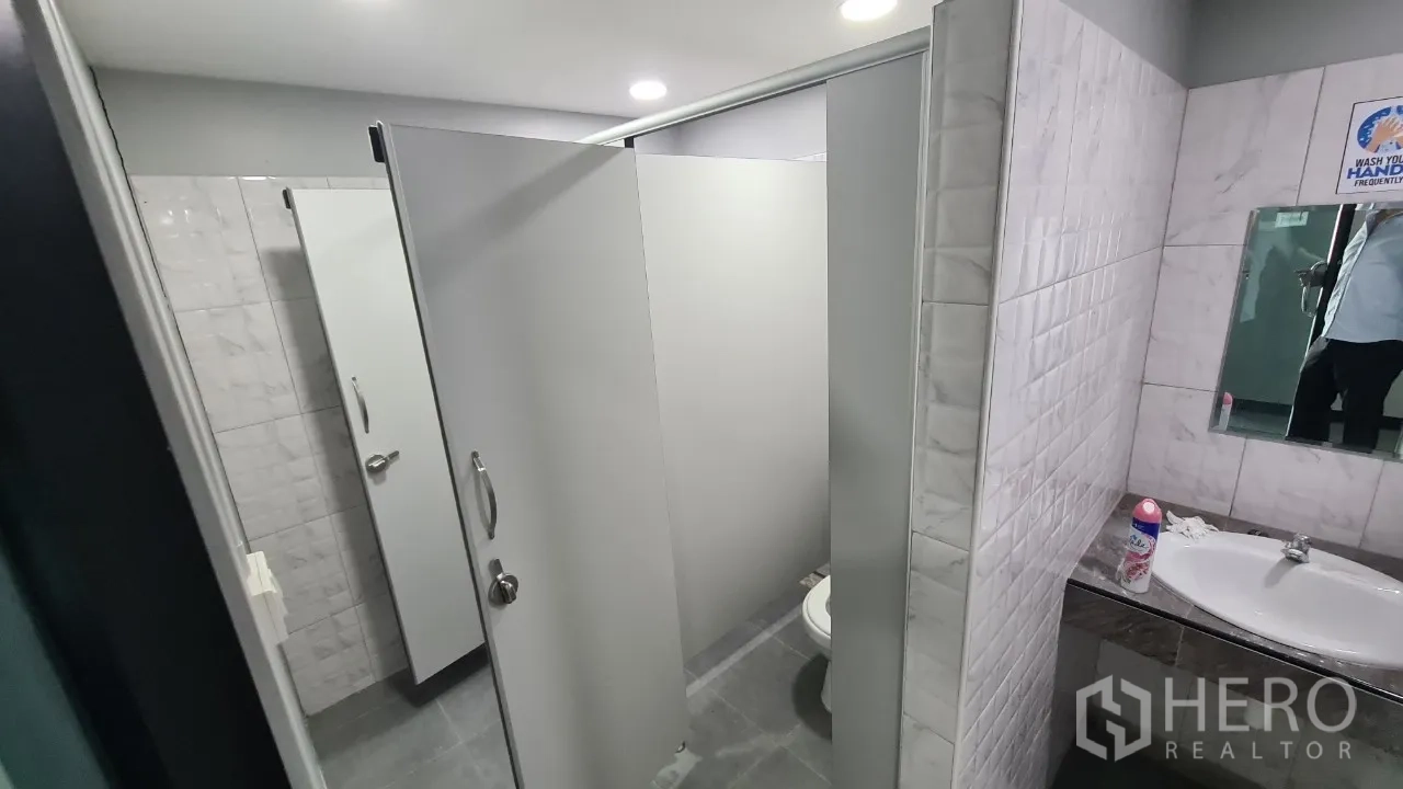 Home Office for rent in Pathum Thani - Restroom area with private cubicles, tiled walls and a basin counter.