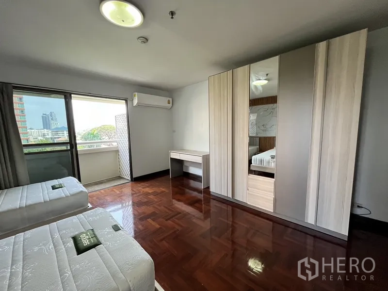 Condominium for rent in Watthana, Bangkok - Twin bedroom with balcony access, large wardrobe and air conditioning.