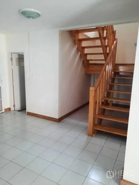 Home Office for rent in Watthana, Bangkok - Open wooden staircase in a tiled foyer area.