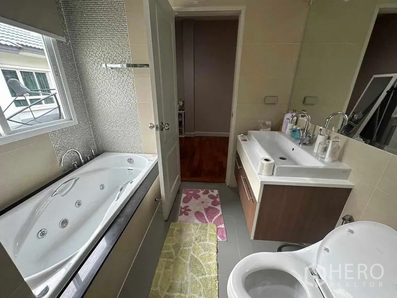 Detached House for sale in Saphan Sung, Bangkok - Modern bathroom with jetted bathtub, vanity and a window for natural light.