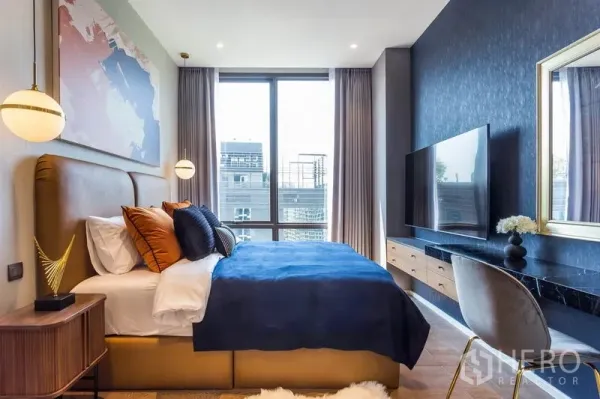 คอนโด ให้เช่าหรือขายในPathum Wan, Bangkok - ห้องนอนสว่างด้วยหน้าต่างบานใหญ่ ผนังสีน้ำเงิน ทีวีและโต๊ะทำงาน ในคอนโดมิเนียมปทุมวัน กรุงเทพฯ