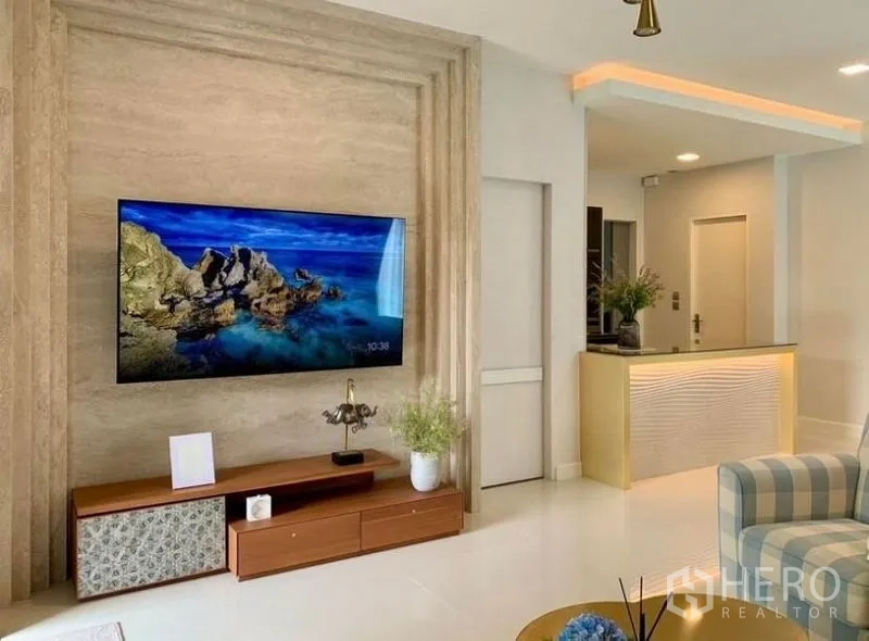 Detached House for rent in Bang Phli, Samut Prakan - Living room with TV feature wall, media console and open counter to pantry.