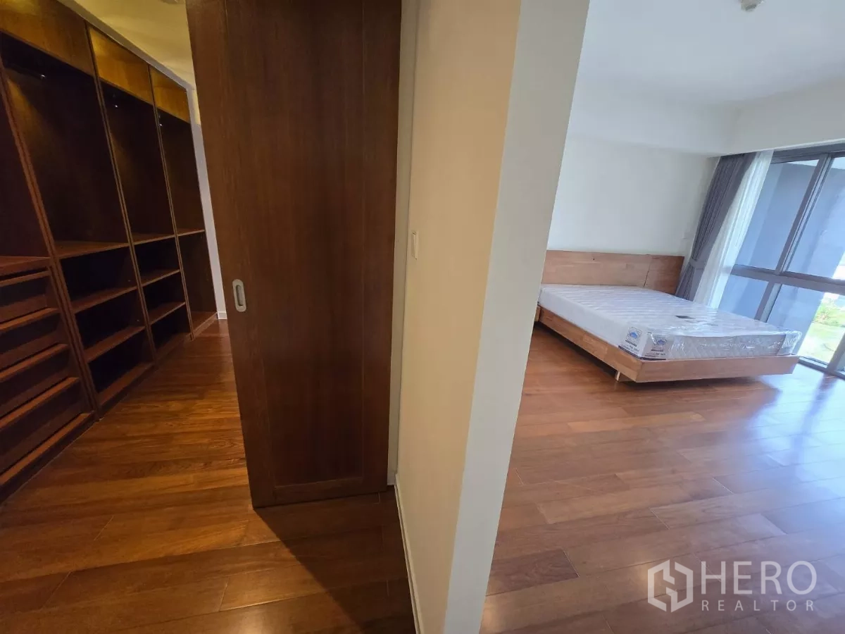 公寓 出租在Yan Nawa, Bangkok - 步入式衣帽间设开放层架，通往带落地窗的卧室。