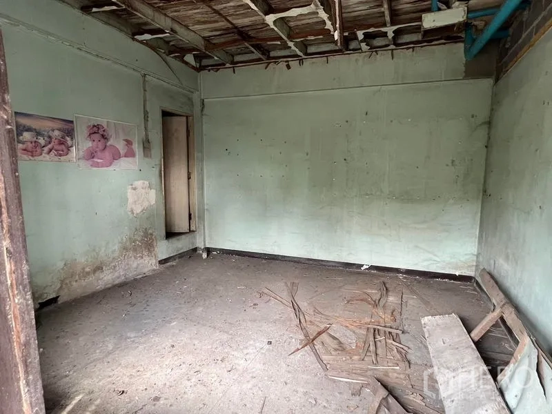 Shophouse for rent or sale in Bang Khen, Bangkok - Empty interior room needing renovation with wall pipes and debris on the floor.