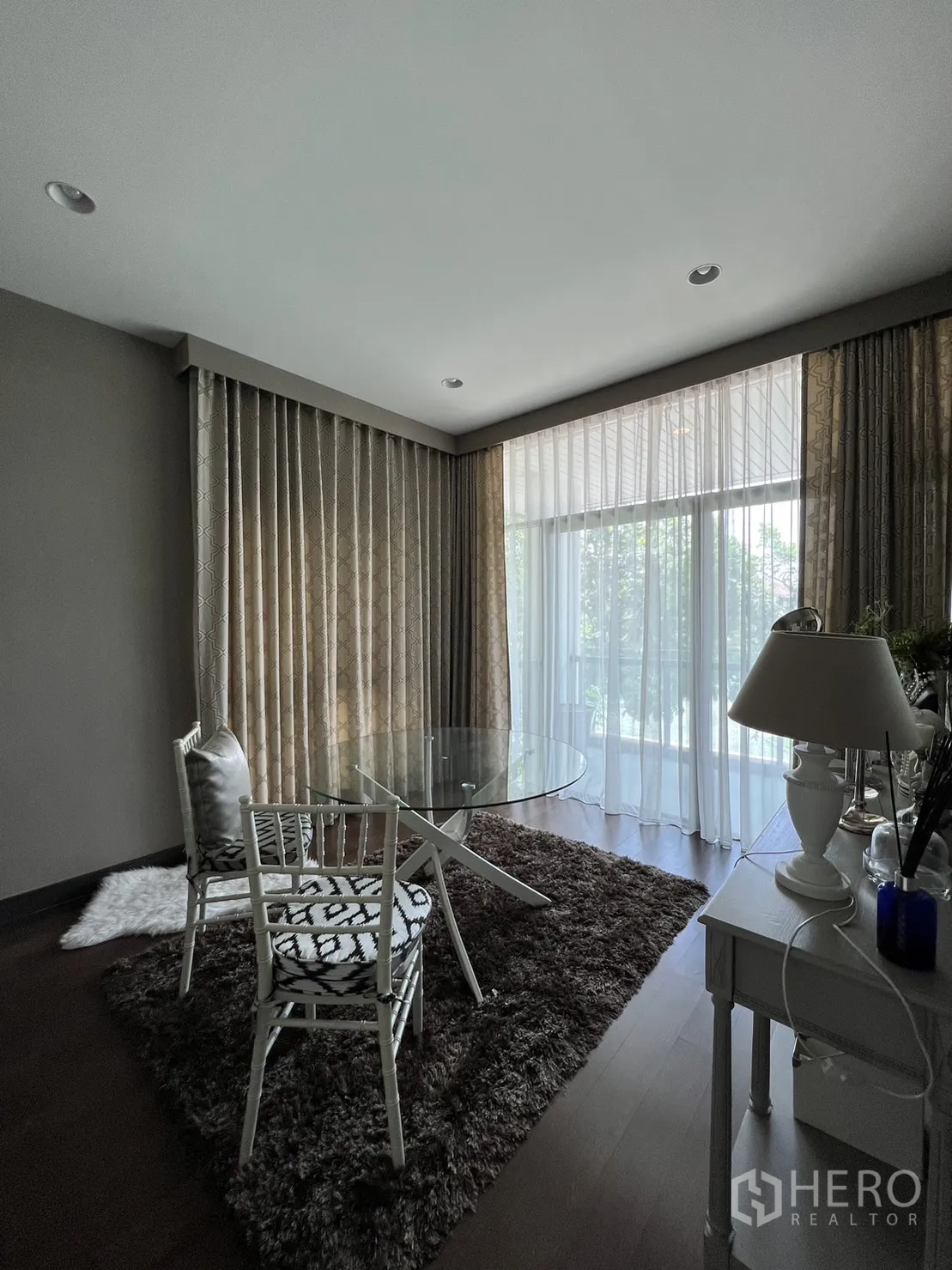 Detached House for rent or sale in Bang Kapi, Bangkok - Sunlit corner room with round glass table on a shag rug.