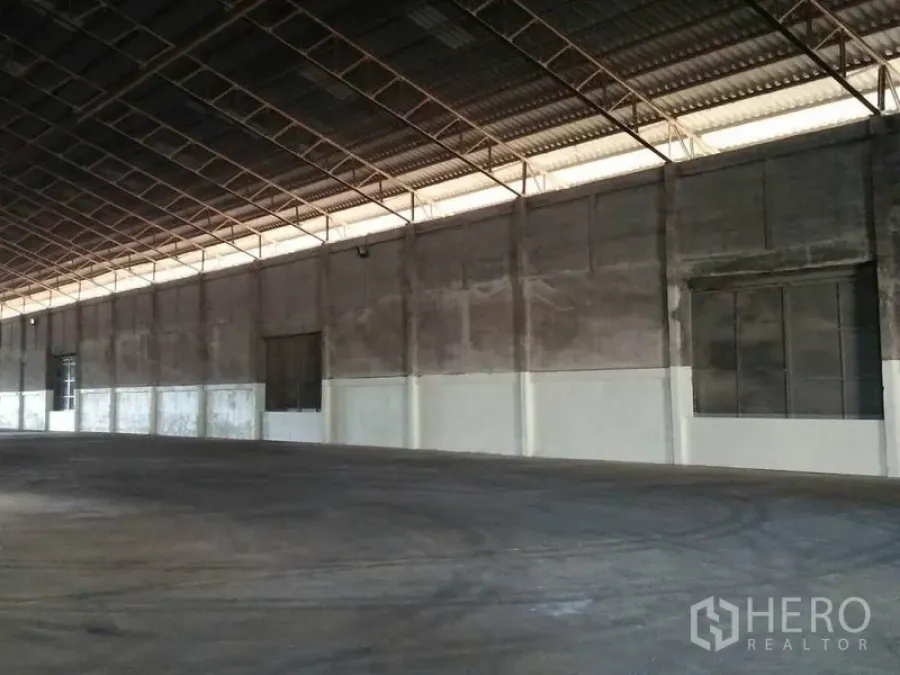 货栈 出租在Pathum Thani - 仓库侧墙，高檐与混凝土地面，沿墙设有大型开口与装卸位。