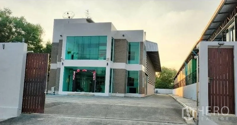Warehouse for rent in Bang Bua Thong, Nonthaburi - Modern two-storey glass-front office and warehouse with wide gated driveway