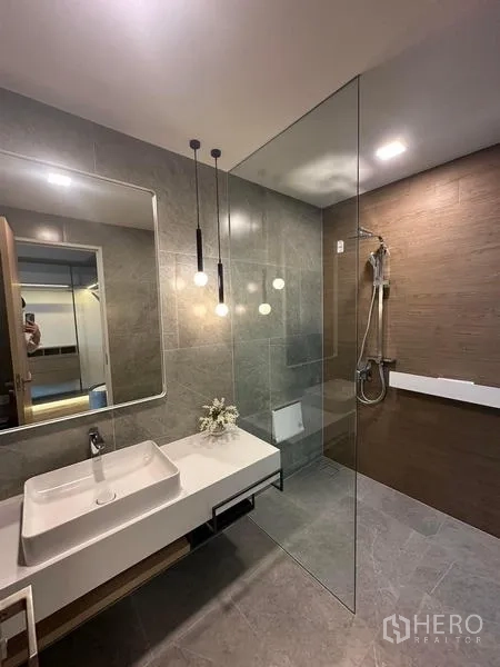 Detached House for rent in Samut Prakan - Contemporary bathroom with walk-in glass shower and floating vanity.