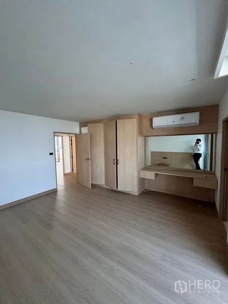 อพาร์ทเมนท์ ให้เช่าในKhlong Toei, Bangkok - ห้องนอนกว้างพร้อมตู้เสื้อผ้าและโต๊ะเครื่องแป้ง พื้นไม้ และแอร์ผนัง