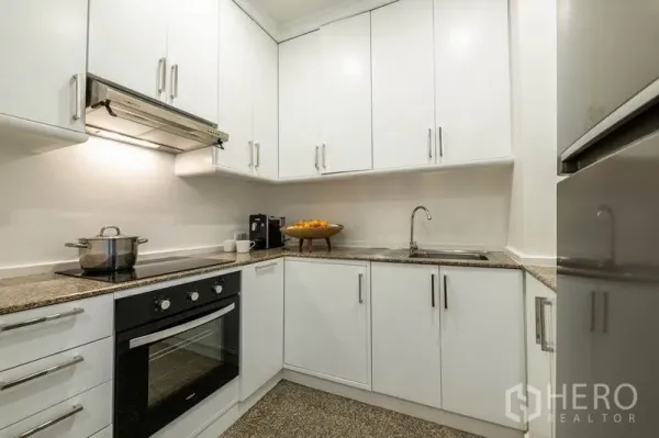 คอนโด ให้เช่าหรือขายในKhlong San, Bangkok - ครัวรูปตัวแอลตู้สีขาว พร้อมเตาอบบิวท์อินและเตาไฟฟ้า