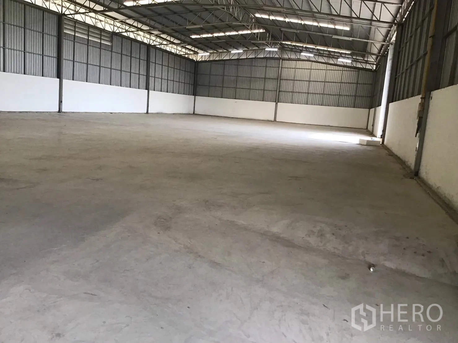 Warehouse for rent in Lat Krabang, Bangkok - Open-plan storage hall with steel columns, ventilation panels, and concrete flooring.